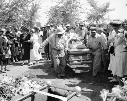 Black and white photo of men carrying the casket to the gravesite