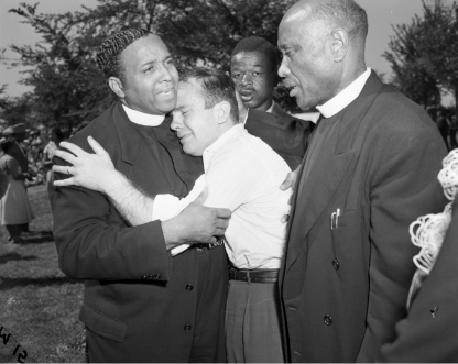 Black and white photo of clergy comforting each other