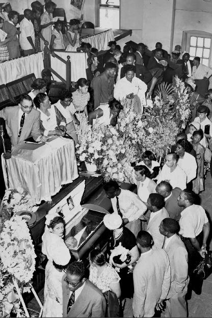 Black and white photo of people viewing Emmett's open casket